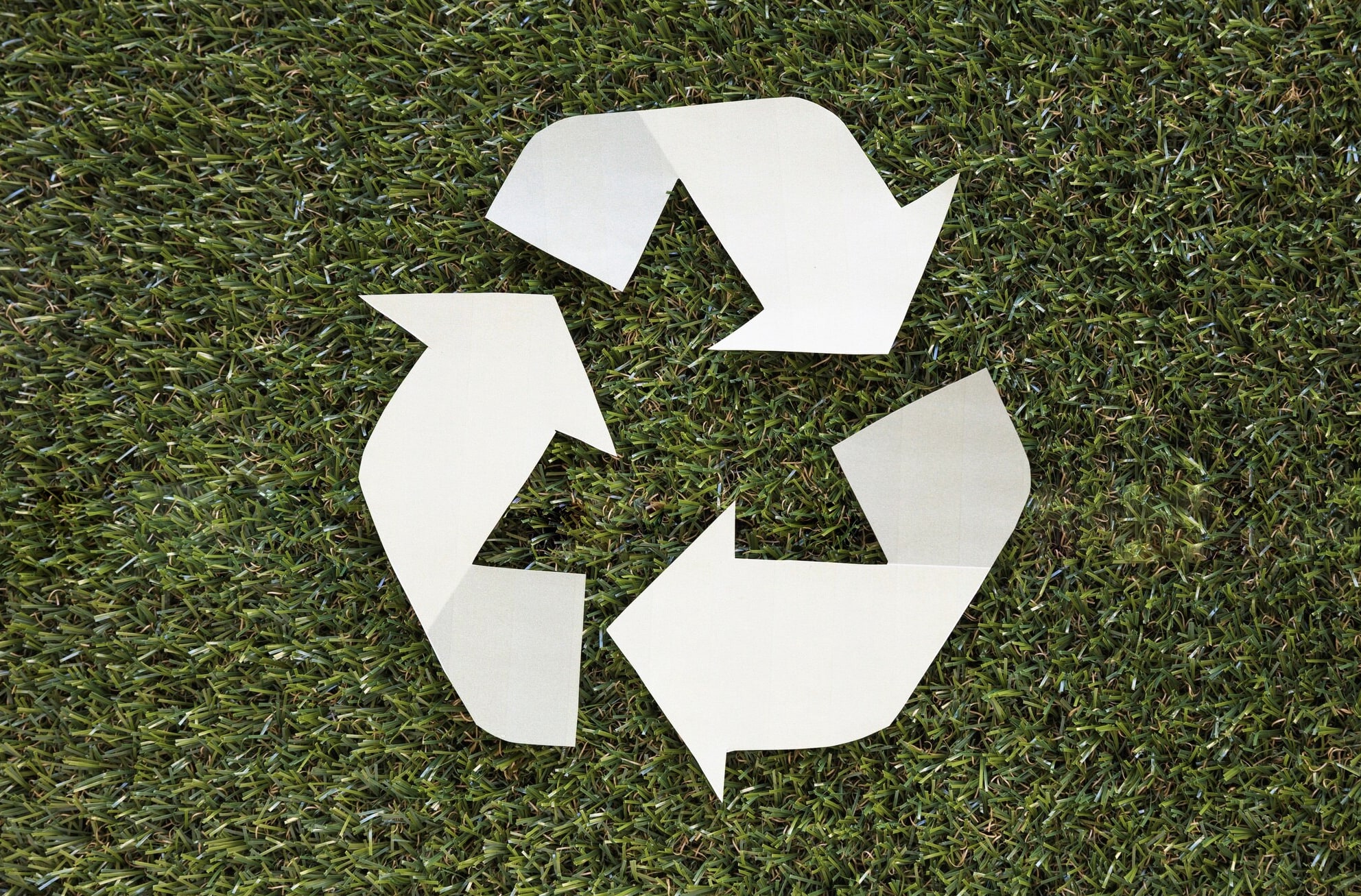 Symbole recyclage papier sur herbe.